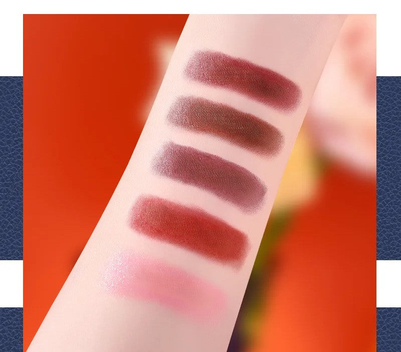 Velvet matte lipstick colour swatches — five complementary shades from the 5-piece gift set displayed with orange leather chain bag