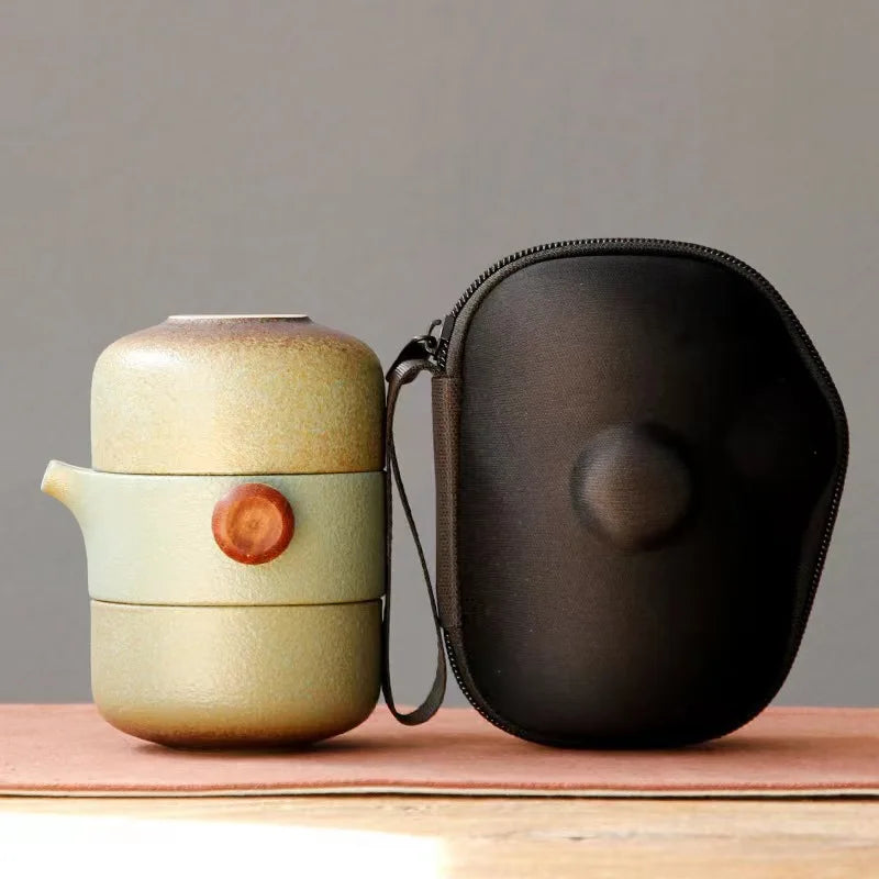 MiniSolutions green ceramic travel tea set with teapot and cup stacked beside its black zip carry case on a wooden surface