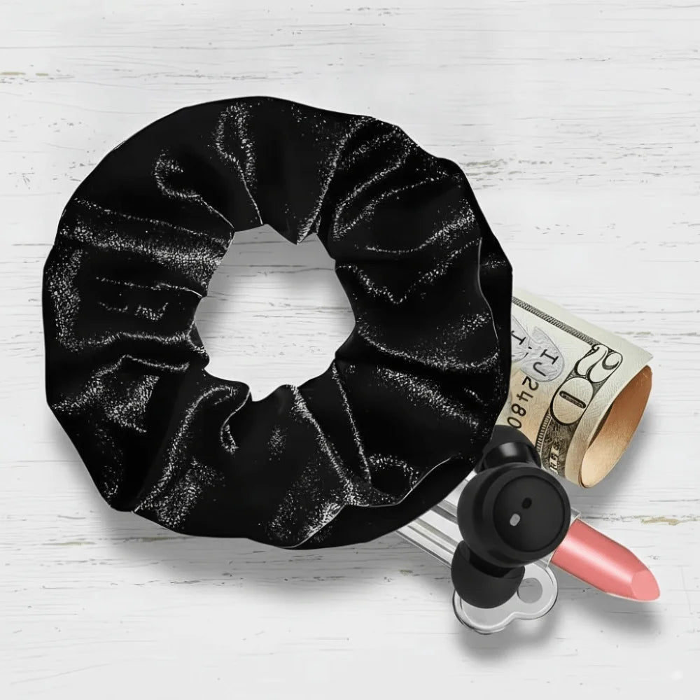 Hidden closure hair scrunchie in black velvet with zipper storage pocket showing items that can be stored