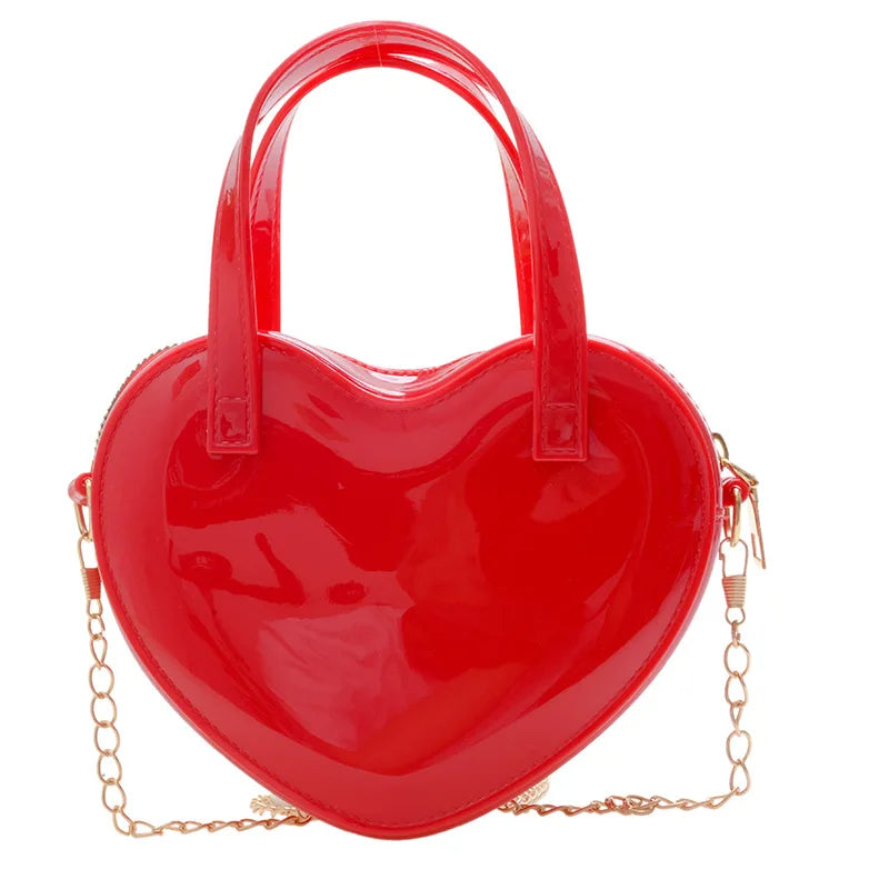 Red heart-shaped handbag front view with twin handles and gold chain strap