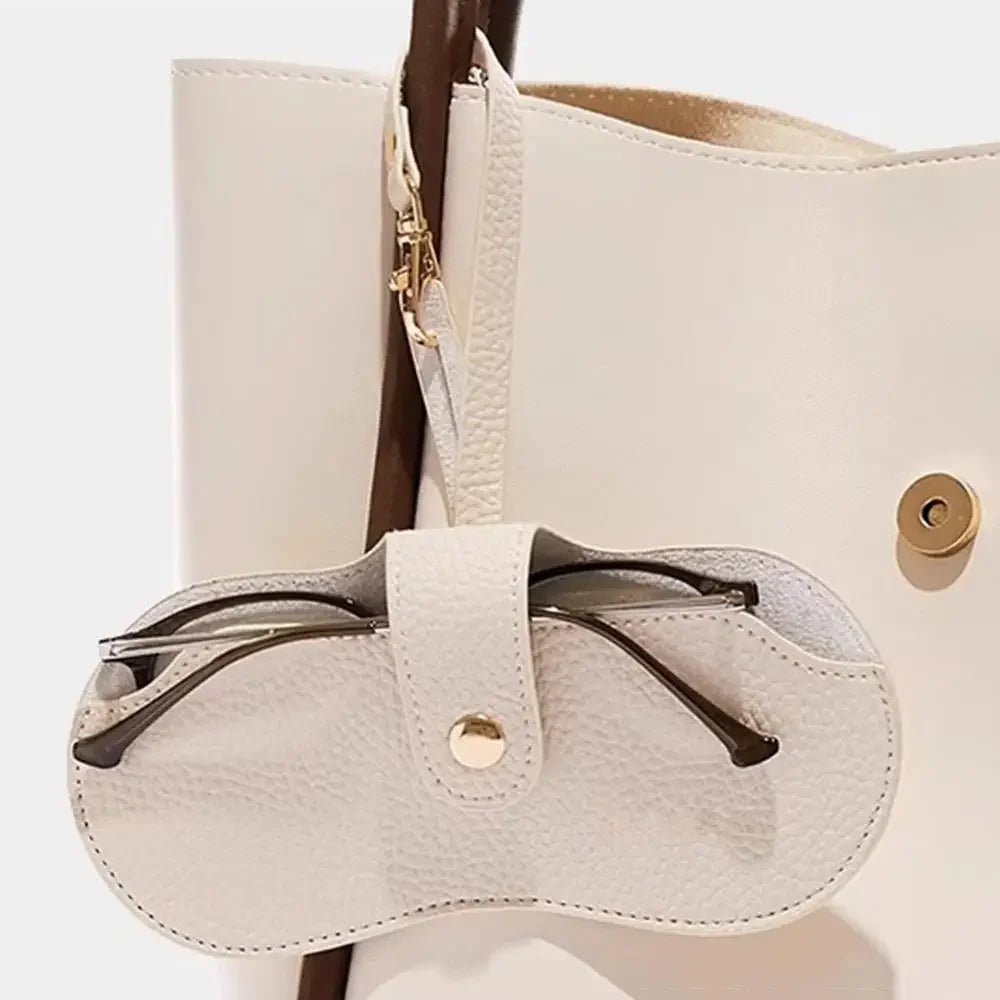 MiniSolutions oval glasses case in ivory clipped to a handbag strap 