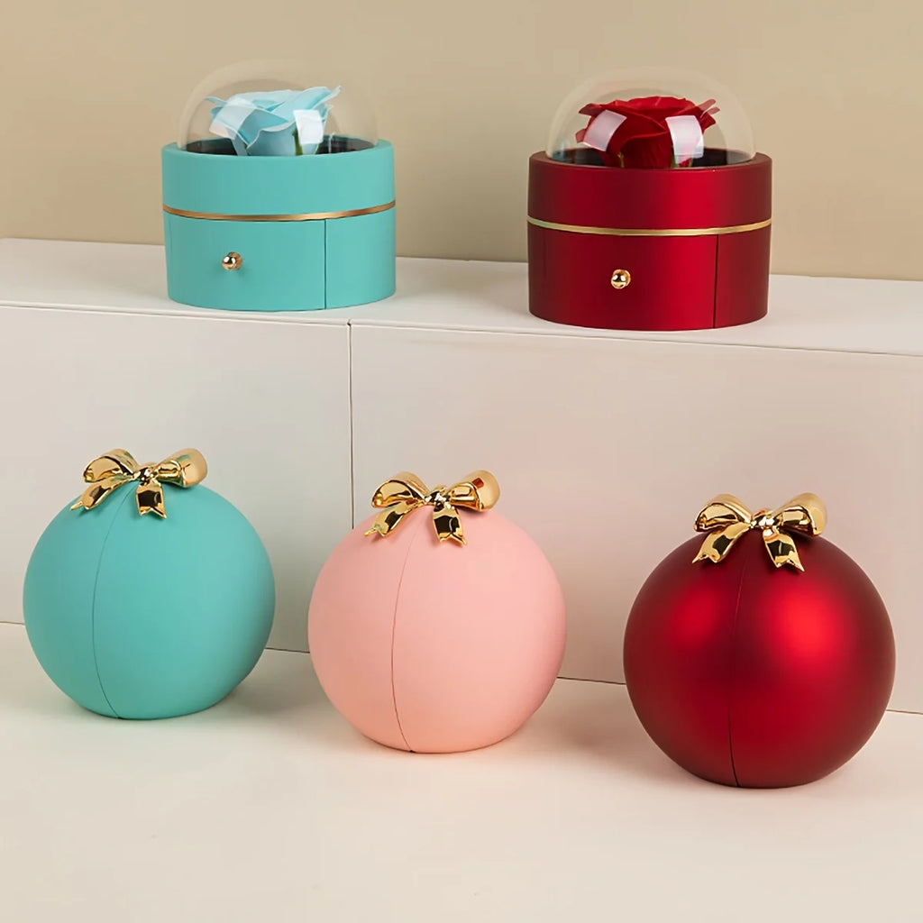 Two styles of rose jewellery box in blue and red, with turquoise, pink and red ball boxes topped with gold-tone bows