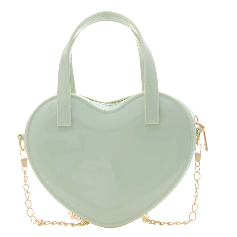 Green heart-shaped handbag front view with twin handles and gold chain strap