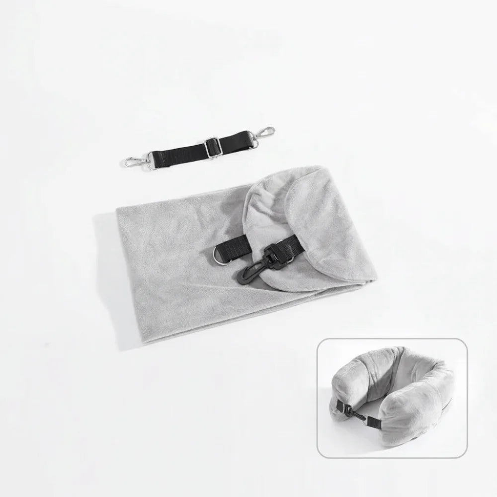 Fillable travel neck pillow in grey shown flat in storage bag with adjustable shoulder strap alongside