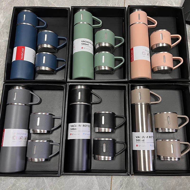 Set of vacuum insulated mugs and bottles in various colors displayed in black boxes.