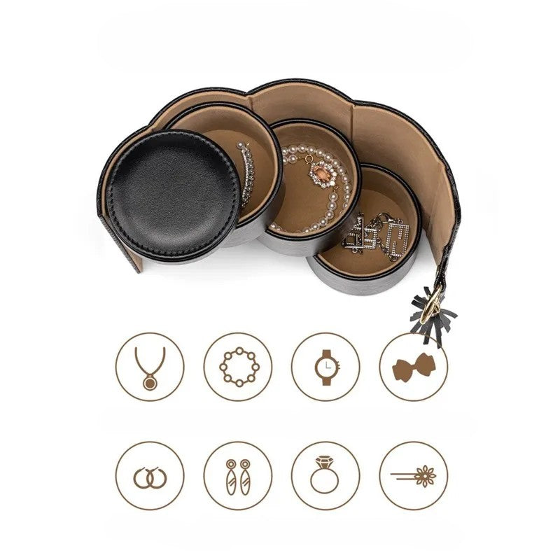 Black leather cylinder jewellery box open showing compartments storing necklaces, bracelets, watches, hair grips, earrings, ear studs, rings and brooches