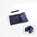 Fillable travel neck pillow in navy blue shown flat in storage bag with adjustable shoulder strap alongside