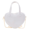 White heart-shaped handbag front view with twin handles and gold chain strap