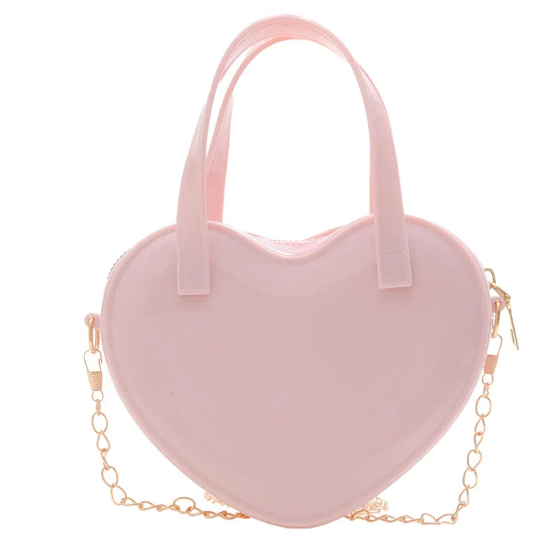 Pink heart-shaped handbag front view with twin handles and gold chain strap