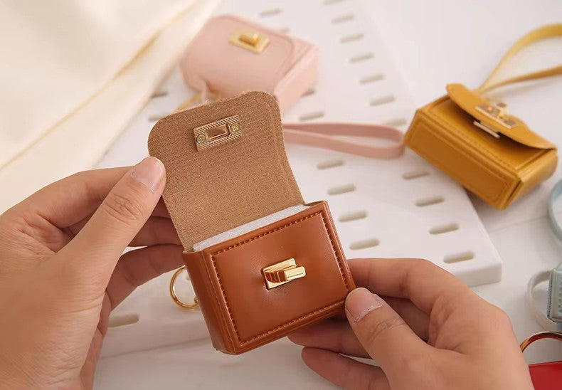 Close-up of kawaii mini bag charm keychain showing turn-lock clasp detail and stitching