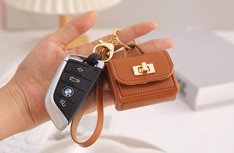 Close-up of kawaii mini bag charm keychain showing turn-lock clasp detail stitching attached to a key Fob
