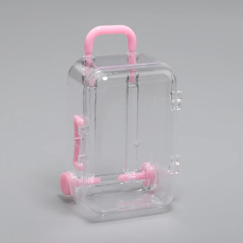 Transparent acrylic mini suitcase display box with pink color-matched handle, wheels, and latch